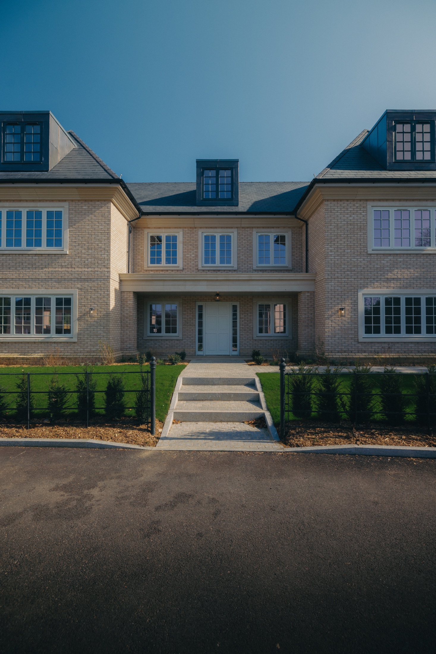 Completed pale-brick home at Park View, with slate roofs and landscaped frontage