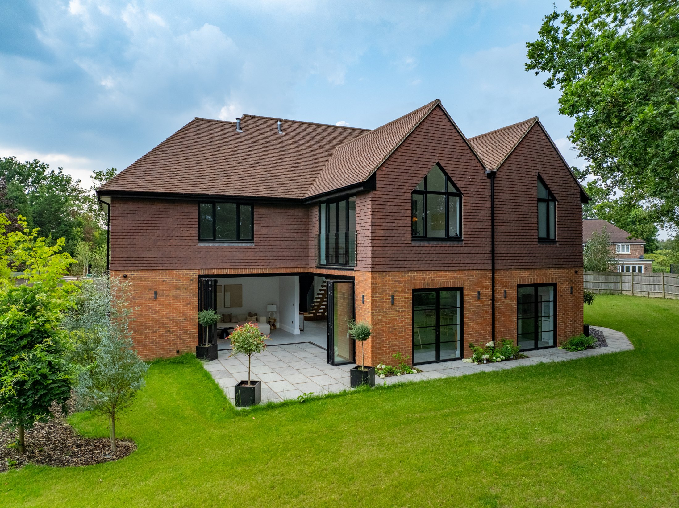 Rear elevation of Persia Place with corner bifold doors opened onto the patio
